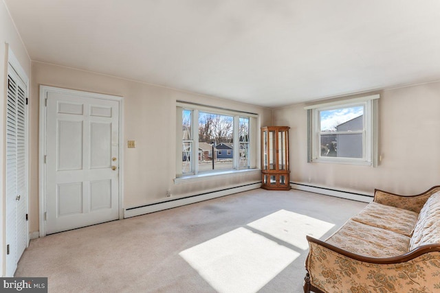 sitting room with light colored carpet and a baseboard heating unit