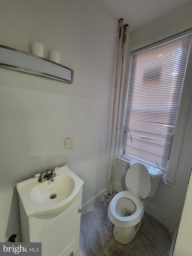 bathroom featuring vanity, toilet, and plenty of natural light