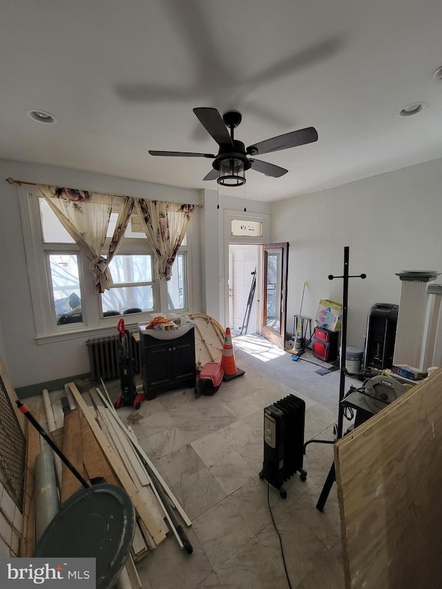 interior space with ceiling fan and radiator heating unit