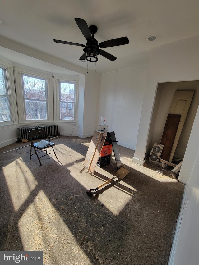 interior space with ceiling fan and radiator heating unit