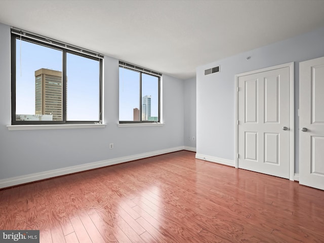 unfurnished room with hardwood / wood-style flooring