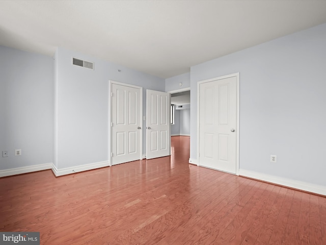 unfurnished bedroom with hardwood / wood-style floors