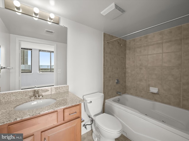 full bathroom with vanity, tiled shower / bath combo, and toilet