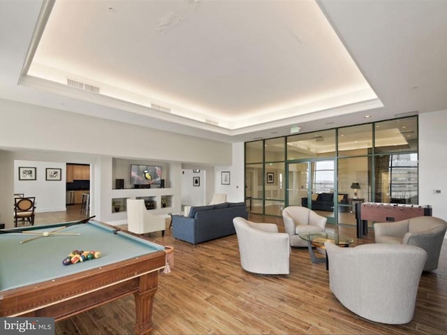 rec room with a raised ceiling, billiards, and hardwood / wood-style floors