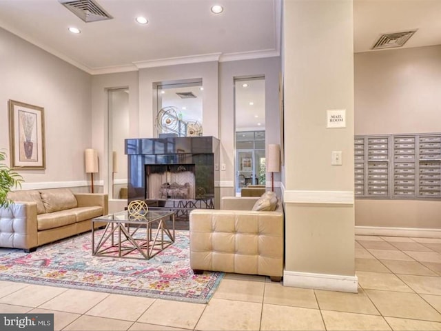 living room featuring ornamental molding, a tile fireplace, a mail area, and light tile patterned floors