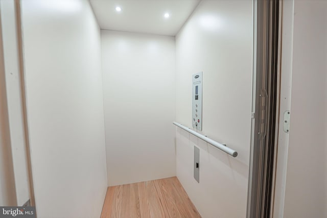 interior details featuring hardwood / wood-style flooring and elevator