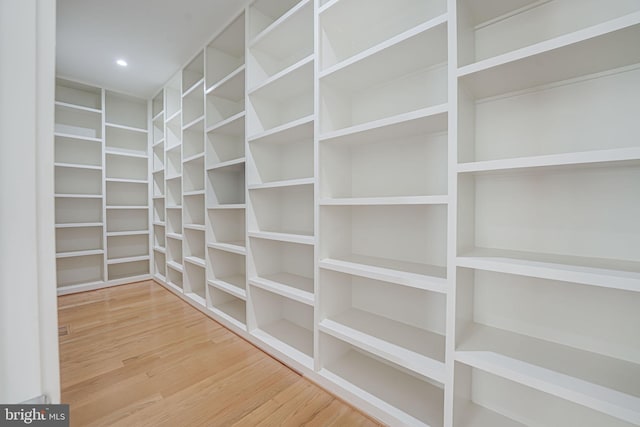 walk in closet with hardwood / wood-style floors