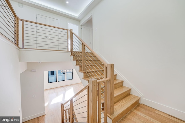 stairs featuring hardwood / wood-style flooring and plenty of natural light