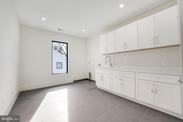 laundry area with light tile patterned flooring, cabinets, washer hookup, and sink