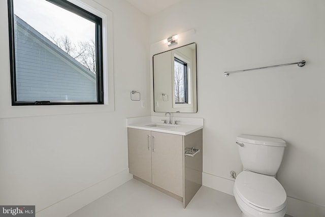 bathroom featuring vanity, plenty of natural light, and toilet