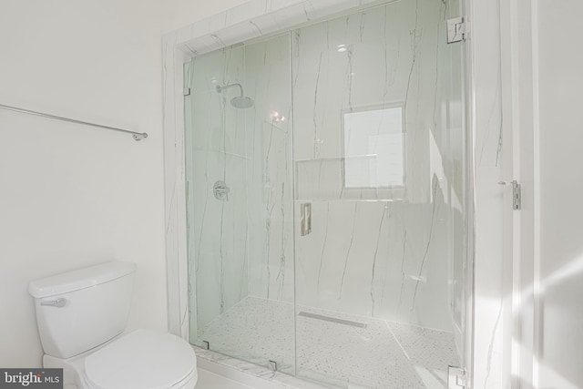 bathroom featuring toilet and a shower with shower door