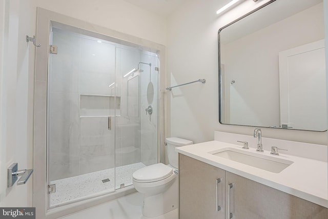 bathroom featuring vanity, an enclosed shower, and toilet