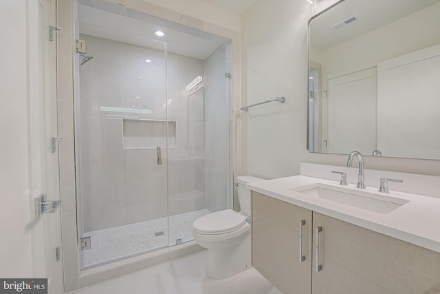 bathroom with an enclosed shower, vanity, and toilet