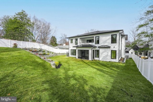 rear view of property with a yard and a sunroom