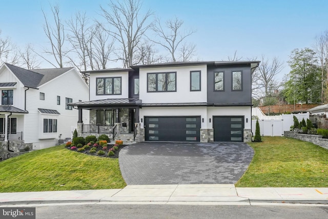 view of front of house featuring a garage, a front yard, and a porch