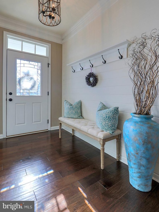 mudroom featuring dark wood-type flooring, a notable chandelier, and ornamental molding