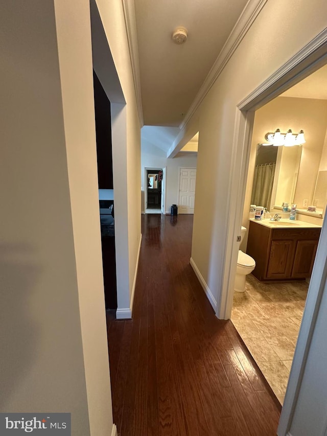 hall with dark hardwood / wood-style floors and ornamental molding