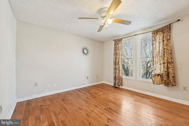 spare room with a textured ceiling, ceiling fan, and hardwood / wood-style floors