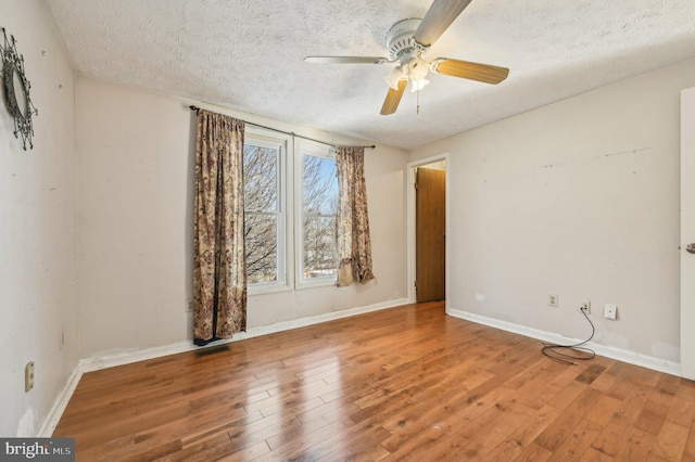 unfurnished room featuring a textured ceiling, ceiling fan, and hardwood / wood-style flooring