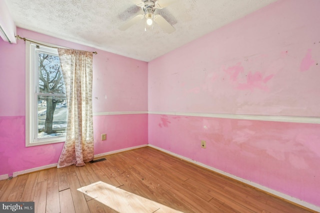 spare room with a textured ceiling, ceiling fan, and hardwood / wood-style flooring