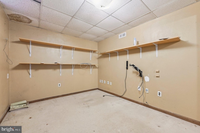 basement with light colored carpet and a drop ceiling