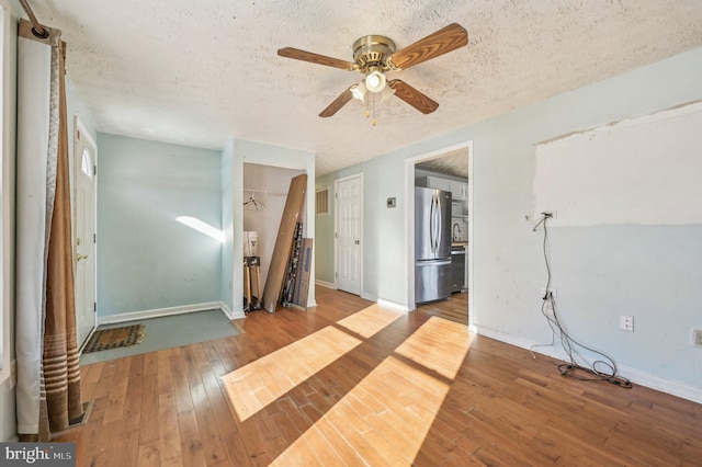 empty room featuring wood-type flooring, a textured ceiling, and ceiling fan