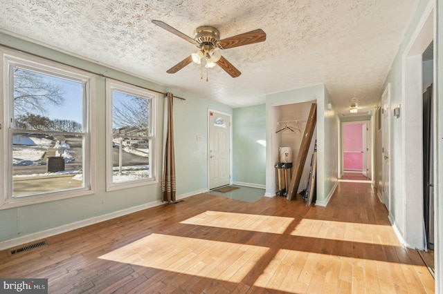 interior space featuring a textured ceiling, ceiling fan, and light hardwood / wood-style flooring