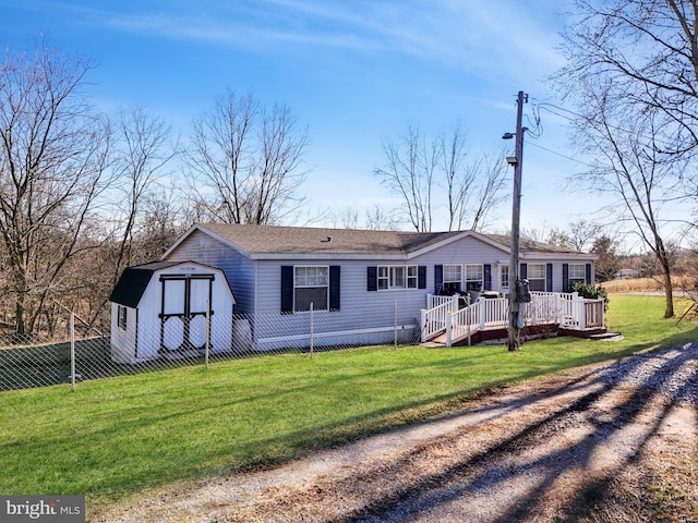 view of front of home with a front lawn, a storage unit, and a deck