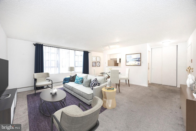 living room featuring track lighting, light colored carpet, a textured ceiling, and a baseboard heating unit