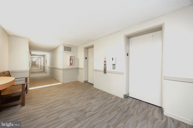 spare room with elevator and a textured ceiling