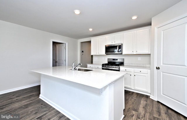 kitchen with sink, white cabinets, stainless steel appliances, and a center island with sink