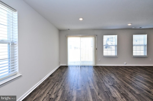 unfurnished room with dark hardwood / wood-style flooring