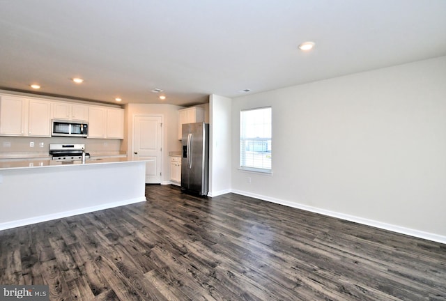 kitchen featuring white cabinets, stainless steel appliances, and dark wood-type flooring