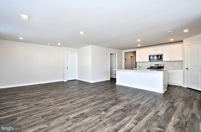 kitchen with white cabinetry, sink, stainless steel appliances, dark hardwood / wood-style flooring, and a kitchen island with sink