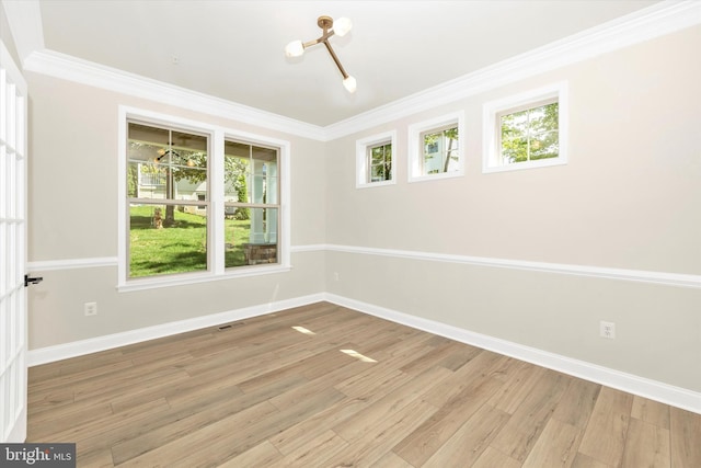 empty room with light hardwood / wood-style floors and crown molding