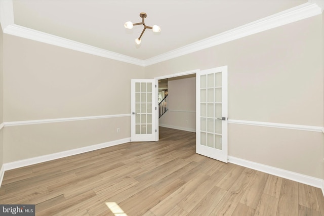 spare room with crown molding, french doors, a notable chandelier, and light hardwood / wood-style flooring