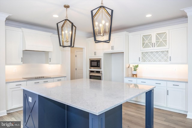 kitchen featuring black appliances, white cabinetry, a center island, and pendant lighting