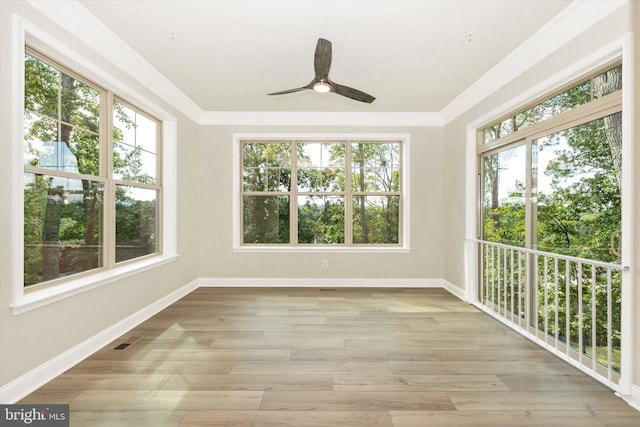 unfurnished sunroom featuring ceiling fan