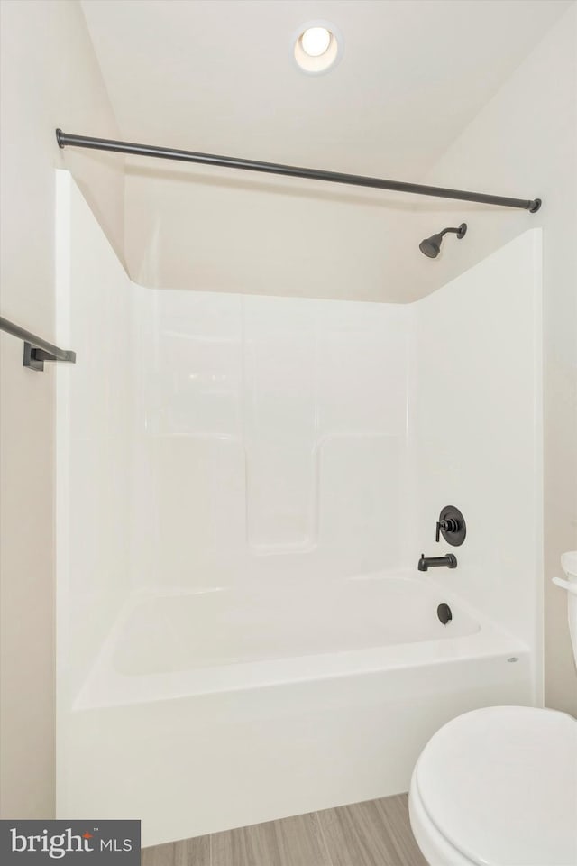 bathroom with shower / bathing tub combination, toilet, and hardwood / wood-style floors