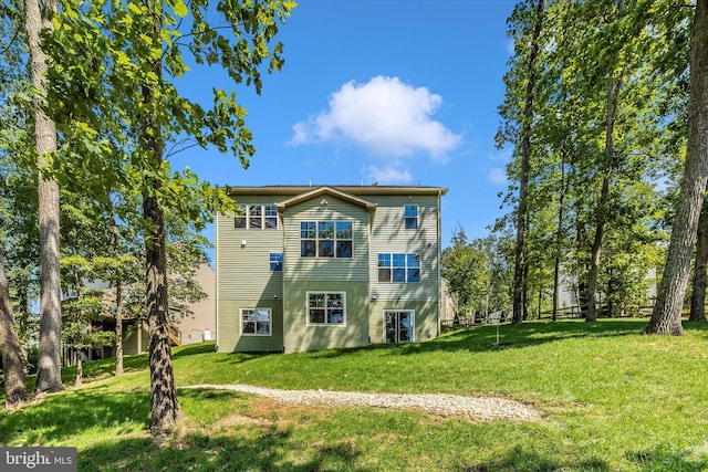 rear view of property featuring a lawn