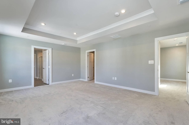 carpeted empty room featuring a tray ceiling