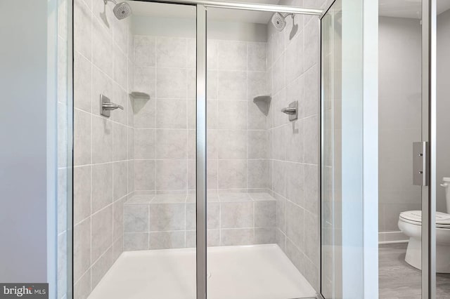 bathroom with toilet and an enclosed shower