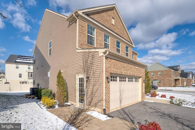 view of home's exterior featuring cooling unit and a garage