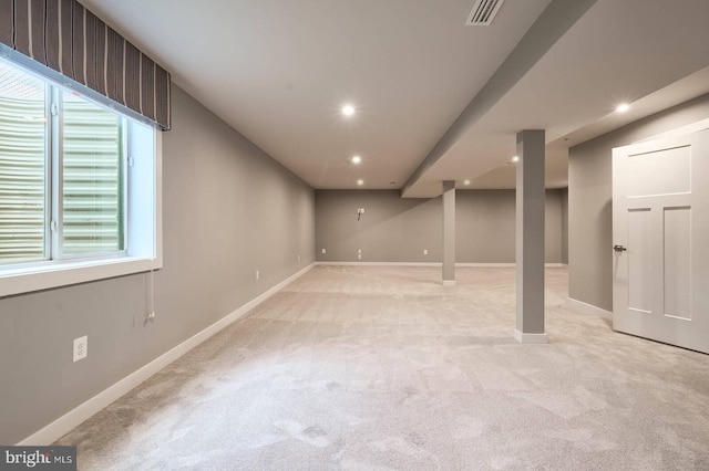 basement featuring a wealth of natural light and light carpet