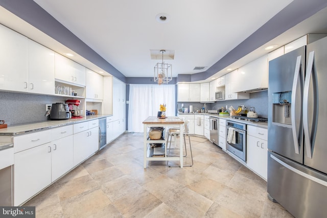 kitchen with decorative backsplash, custom range hood, decorative light fixtures, white cabinetry, and stainless steel appliances