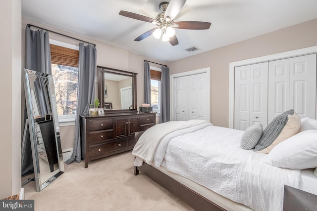 carpeted bedroom with multiple closets and ceiling fan