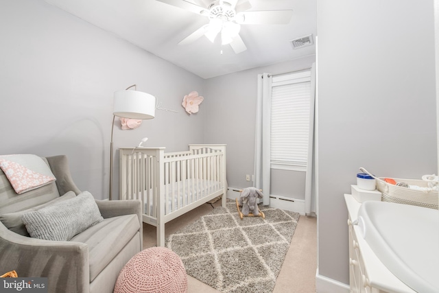 bedroom with ceiling fan and a nursery area