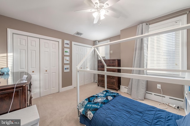 bedroom featuring light colored carpet, baseboard heating, and ceiling fan