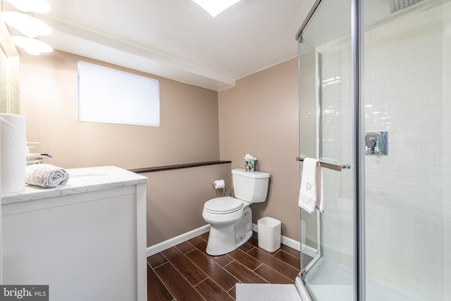 bathroom featuring vanity, toilet, and a shower with shower door