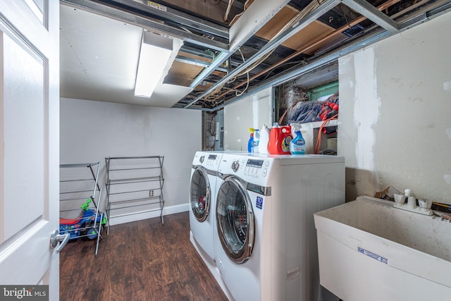 clothes washing area featuring separate washer and dryer, dark wood-type flooring, and sink